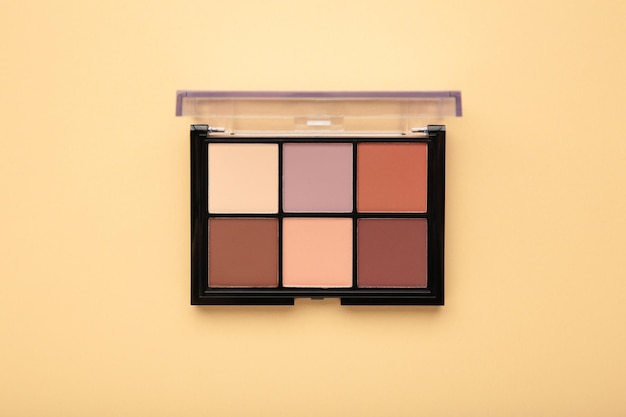 Paleta de sombras básicas sobre fundo bege Conceito de maquiagem