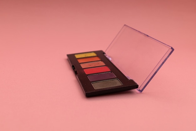 Paleta de sombras em um tiro de pedmetria de fundo rosa