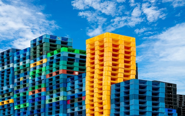 Paleta de envío de plástico para venta y alquiler de negocios. Industria de palets de plástico apilados en el almacén de la fábrica. Concepto de negocio de carga y envío. Pila de palets de plástico.