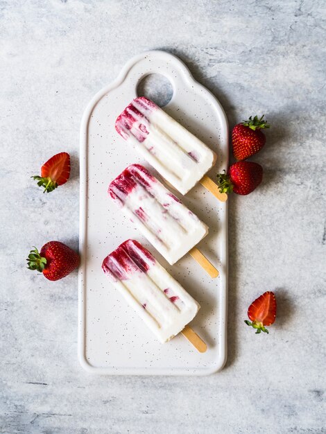 Paleta de fresas frescas y yogurt en una tabla de cerámica