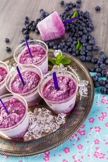 Paleta de frutas casera elaborada en vasos de plástico.