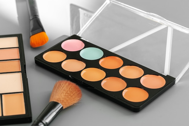 Paleta de maquillaje con correctores de colores sobre gris