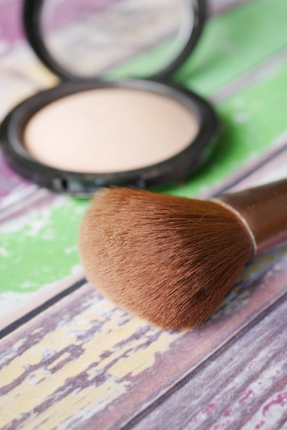 Una paleta con sombras de ojos y un pincel de maquillaje.