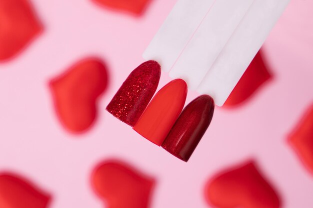 Paletas de colores románticos de esmalte de uñas para manicura y pedicura sobre fondo de corazones