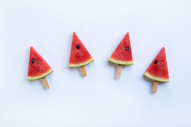 Paletas dulces de la rebanada de la sandía en el fondo blanco