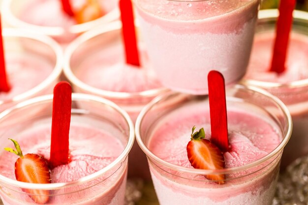 Paletas de fresa caseras hechas en vasos de plástico.