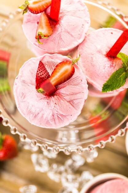 Foto paletas de fresa caseras hechas en vasos de plástico.