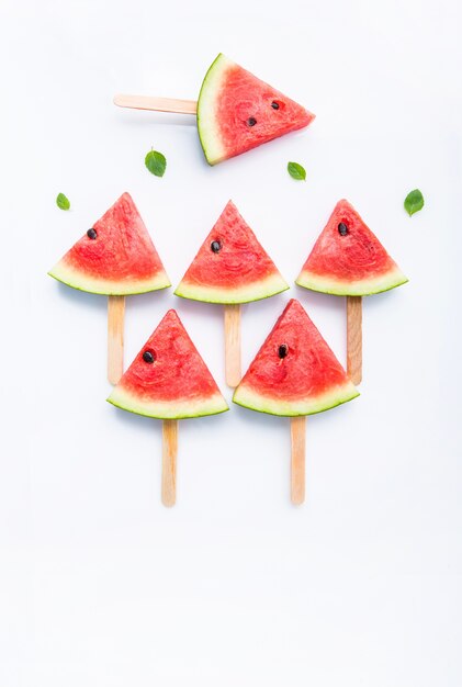 Paletas frescas y dulces de la rebanada de la sandía en el fondo blanco