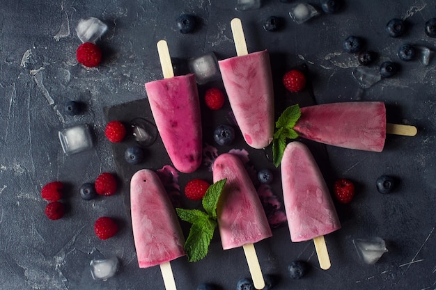 Paletas de frutas congeladas caseras con frambuesa natural fresca y arándanos