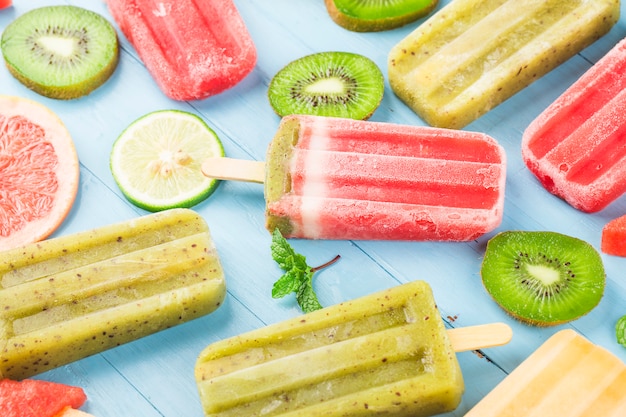 Foto paletas de frutas enteras saludables con bayas kiwi melón sandía en mesa de madera vintage