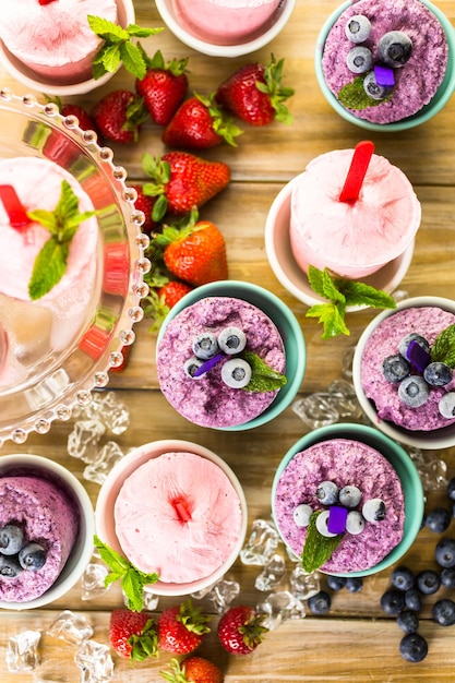 Paletas heladas caseras de arándanos y fresas en vasos de plástico.