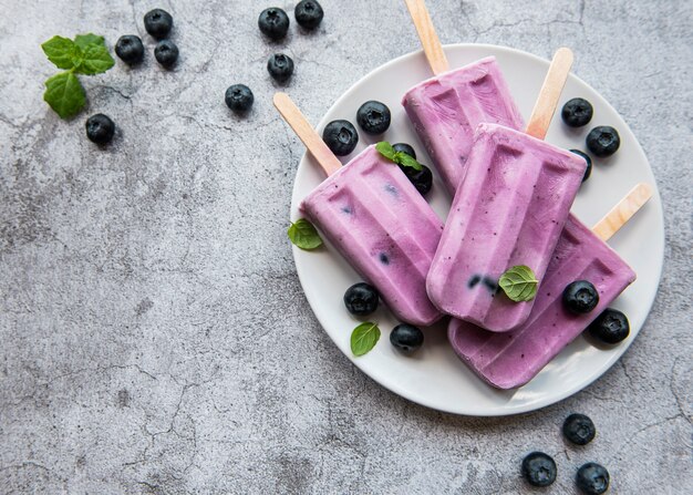 Paletas de helado de yogur casero y arándanos orgánicos frescos.