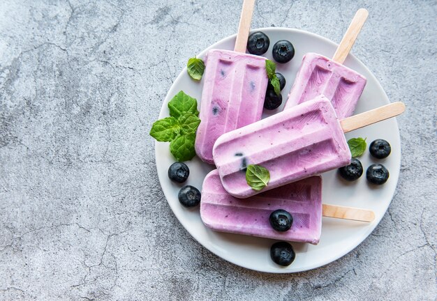 Paletas de helado de yogur casero y arándanos orgánicos frescos.