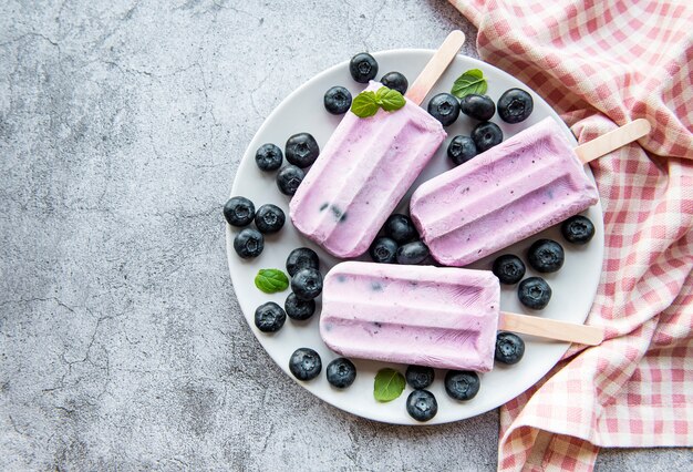 Paletas de helado de yogur casero y arándanos orgánicos frescos.