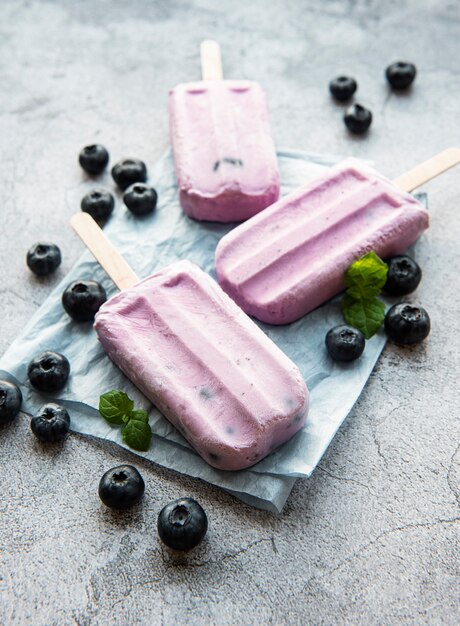 Paletas de helado de yogur casero y arándanos orgánicos frescos.