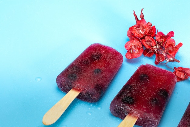 Foto paletas de hielo de arándanos saludables caseras en la pared azul fresca diseño de verano con espacio de copia