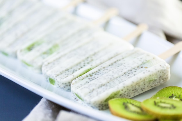 Paletas de kiwi, coco y chia en un plato blanco para servir.