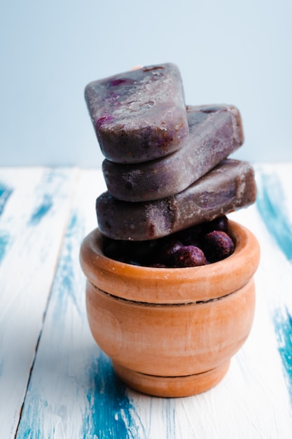 Paletas de leche de coco de arándanos veganos caseros sobre fondo de madera fresca