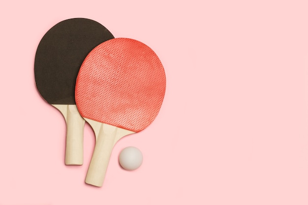 Foto paletas de ping pong rojas y negras con una bola blanca