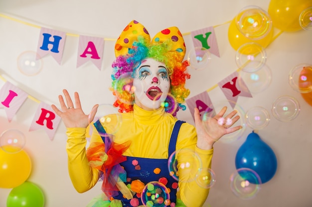 Palhaço alegre de férias entre bolhas de sabão