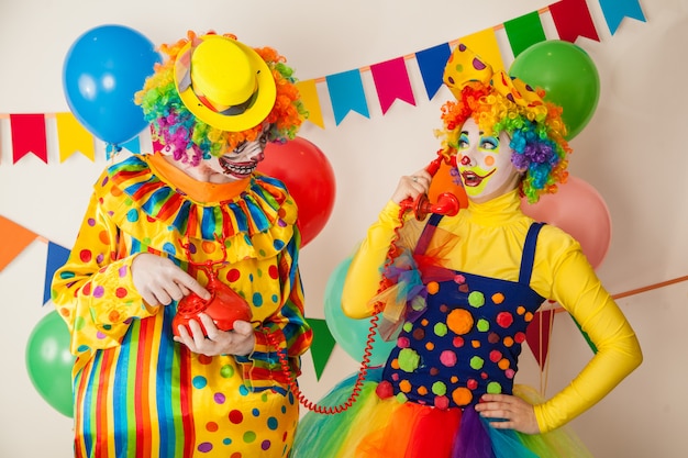 Palhaço alegre e um palhaço assustador em uma festa colorida