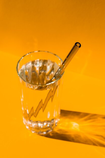 Palhinhas de vidro reutilizáveis em vidro com água em fundo amarelo conjunto de palhinhas de bebida ecológicas com