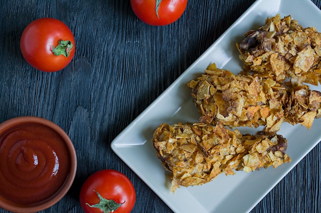 Palillos de pollo asados en una placa.