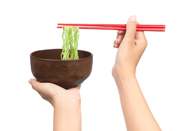 palillos que sostienen los fideos chinos con recipiente aislado sobre fondo blanco.