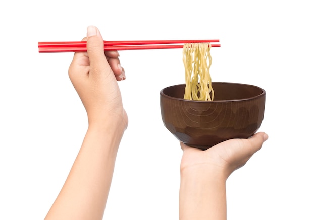 palillos que sostienen los fideos chinos con recipiente aislado sobre fondo blanco.