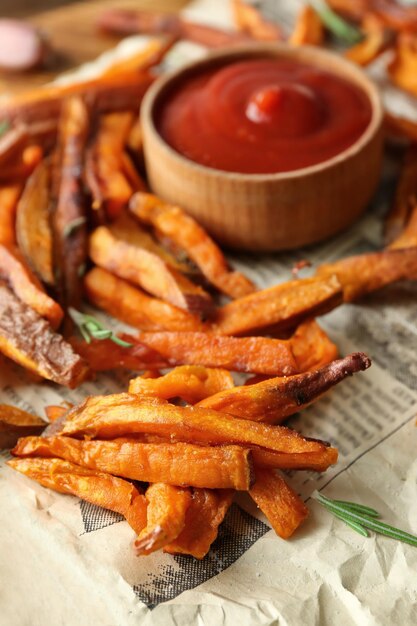 Palitos de batata fritos con salsa en primer plano de papel