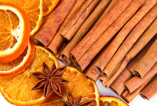 Foto palitos de canela, anís estrellado y cortes secos de naranja.