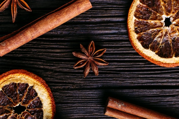 Palitos de canela, anís estrellado y naranja seca en la mesa de la cocina