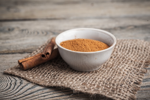 Palitos de canela y canela en polvo en un tazón