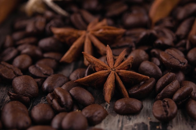 Palitos de canela de chocolate y granos de café sobre fondo de madera