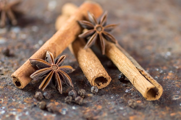 Palitos de canela, estrellas de anís y granos de pimienta negra sobre textura