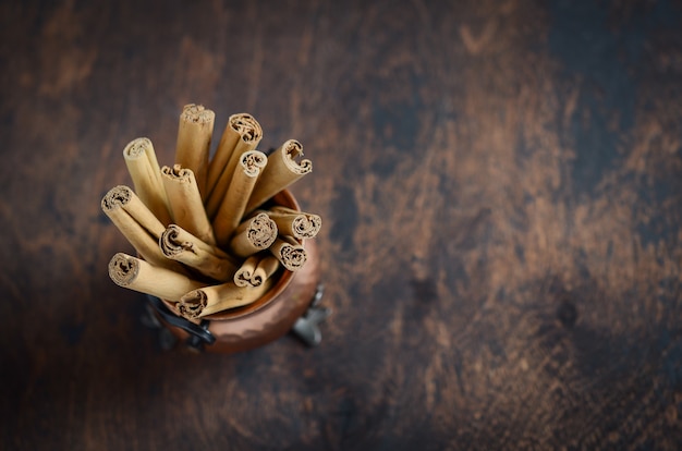 Palitos de canela en una mesa de madera oscura.