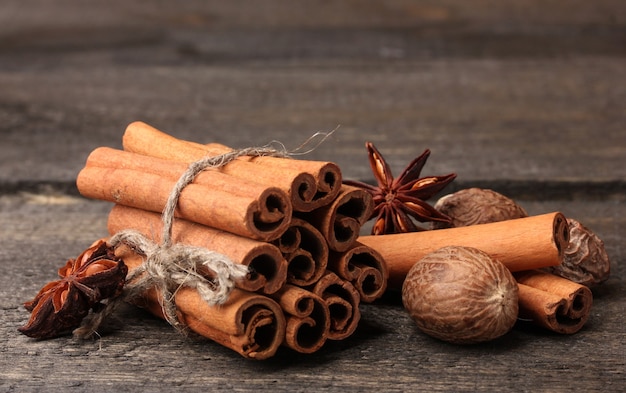 Palitos de canela, nuez moscada y anís sobre mesa de madera