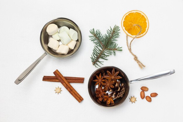 Palitos de canela ramita de abeto y naranja seca en cuerda Malvavisco y anís estrellado en tazones de metal