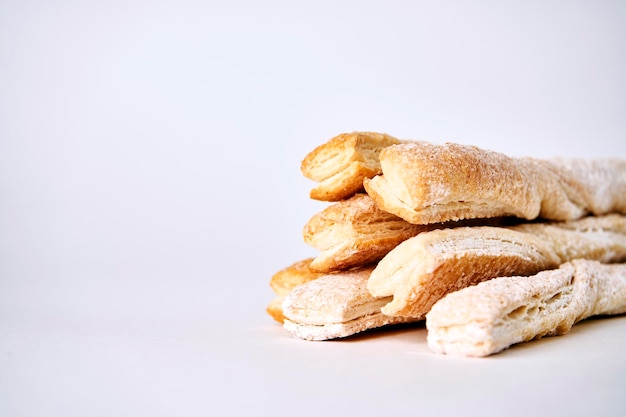 Palitos de hojaldre con canela sobre fondo blanco.