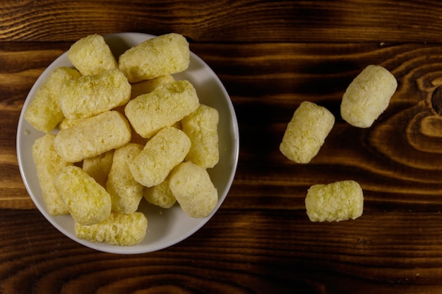 Palitos de maíz dulce en un plato sobre la mesa de madera. Vista superior