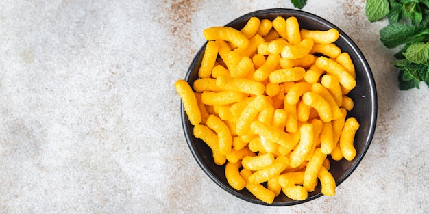 Palitos de maíz con sabor a tocino cheetos comida rápida merienda en la mesa copia espacio comida