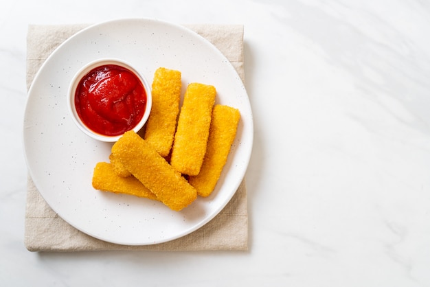 Palitos de pescado frito crujiente con pan rallado servido en un plato