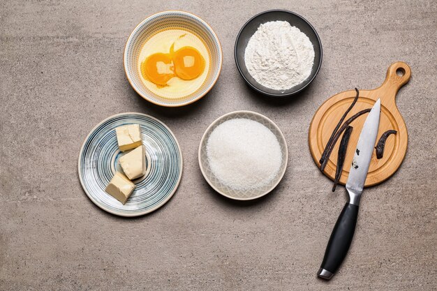 Palitos de vainilla aromáticos e ingredientes para pastelería en mesa