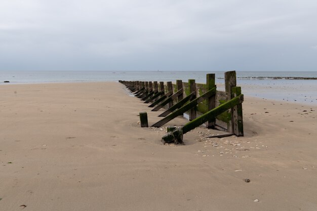 Palizada de madera en la costa para romper olas atacadas