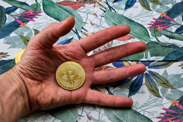 Palma de la mano de un hombre con un bitcoin