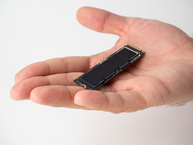 Foto en la palma masculina hay un disco ssd del formato m2. nuevas tecnologías de almacenamiento y transferencia rápida de datos. actualización para dispositivos digitales