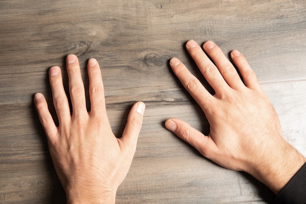 Palmas masculinas en una mesa de madera