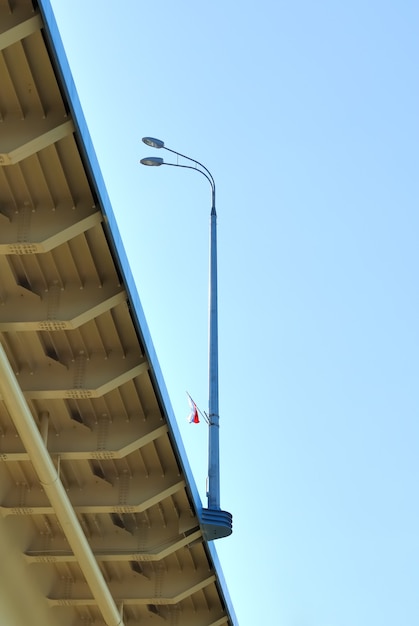 Palmo de puente de postes de luz en el fondo de cielo azul