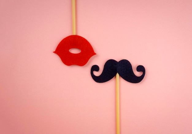 Palo de bigote boca abajo con boca roja en palo aislado sobre fondo rosa pastel con espacio de copia, estilo minimalista.