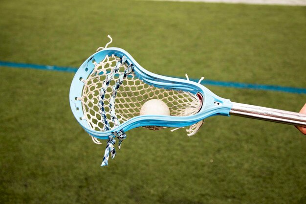 El palo de lacrosse azul de Carolina con una pelota